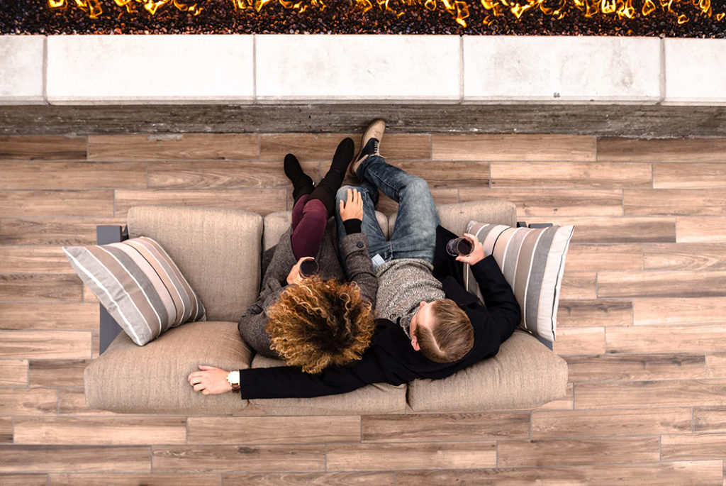 Overhead view of residents relaxing beside a rooftop fire feature at 4th West