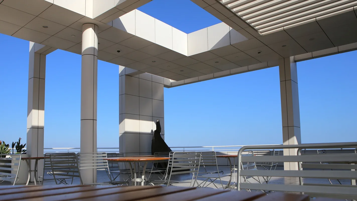 Rooftop terrace under a structural canopy with tables and open views