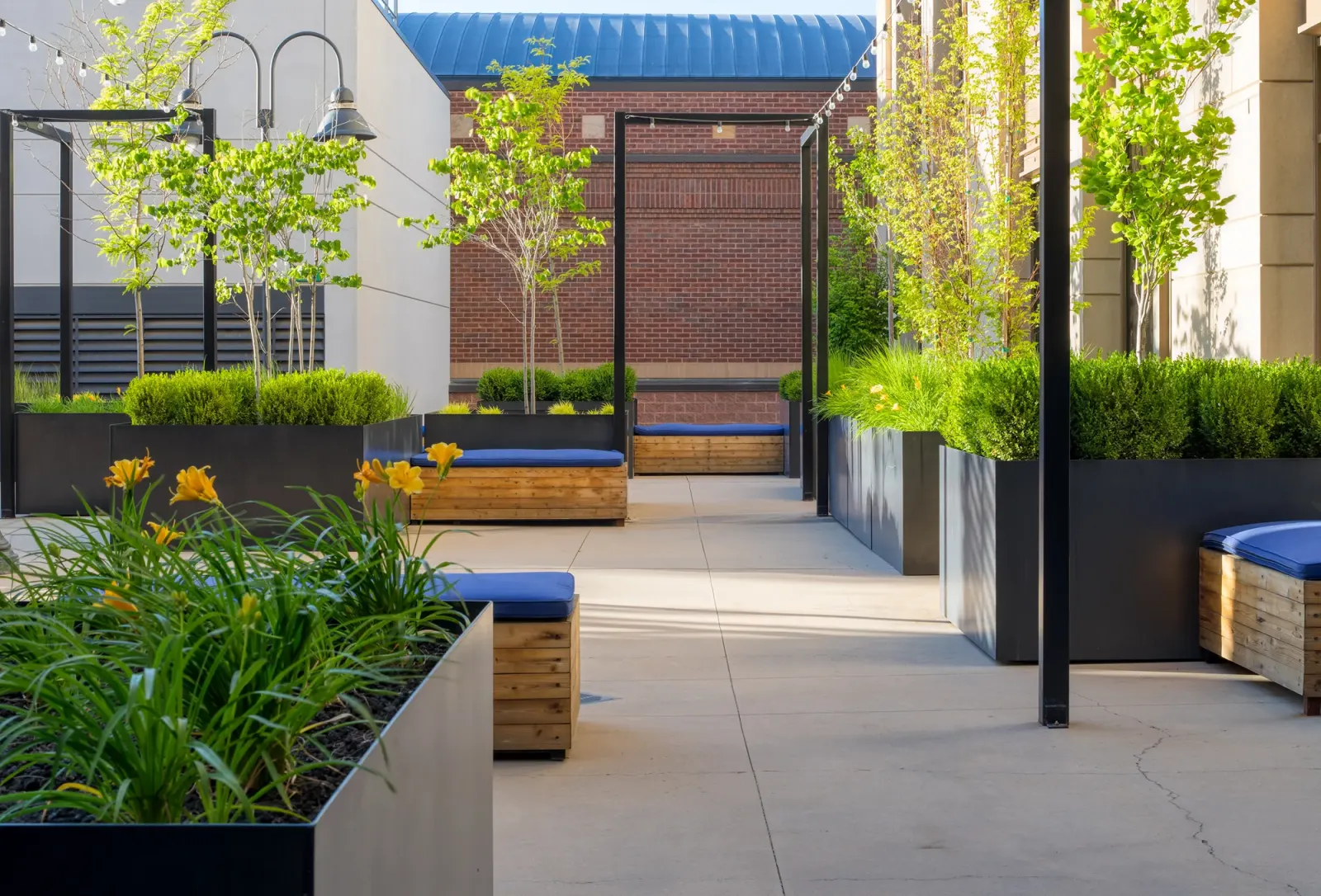 Hidden Gem rooftop office-patio amenity at The Gateway in the evening, bench seating under warm lighting