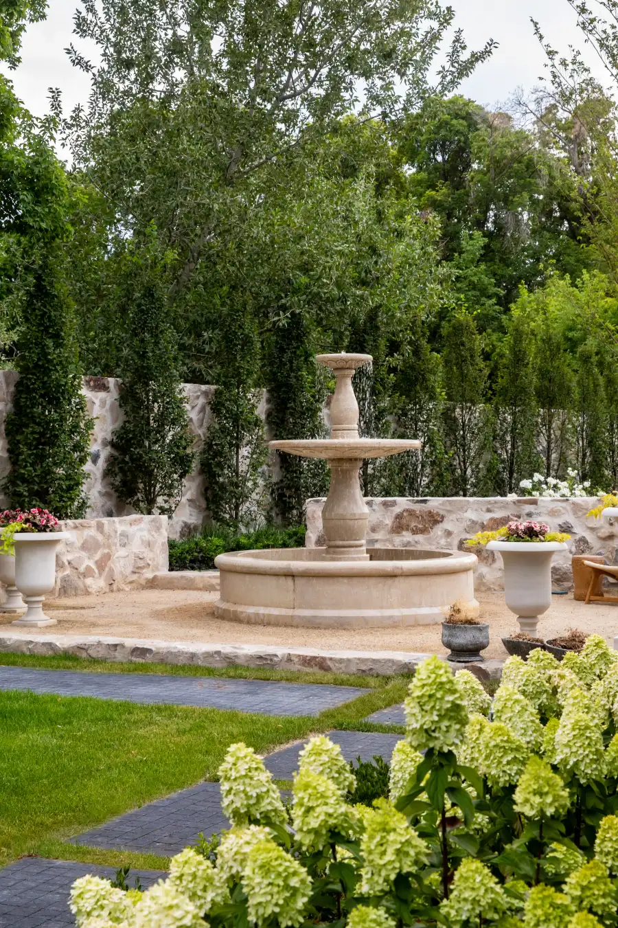 A still garden with a fountain and stone terrace at a Modern Elm residence