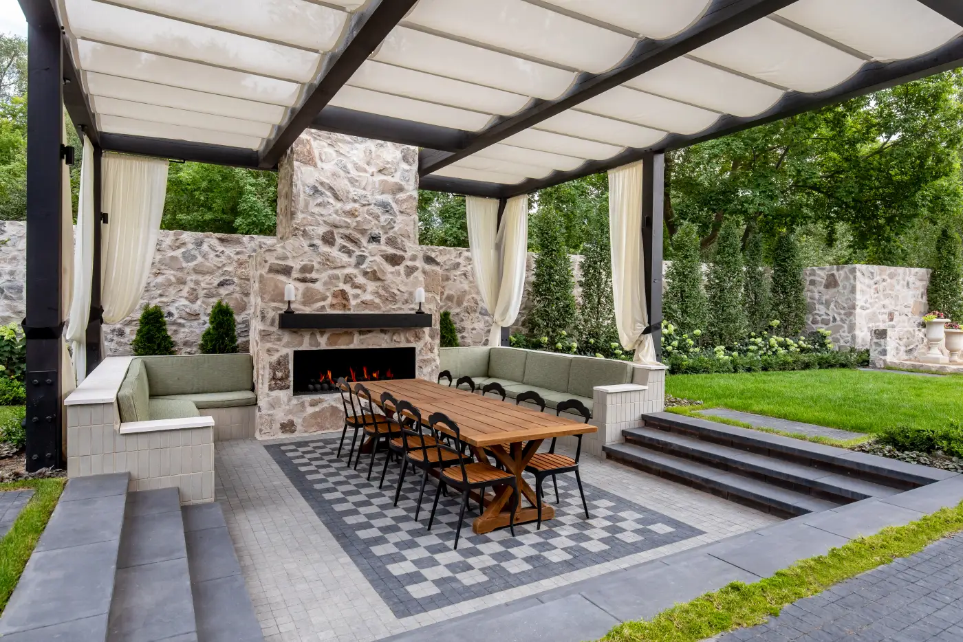 Stone loggia with a fireplace and outdoor dining at Modern Elm