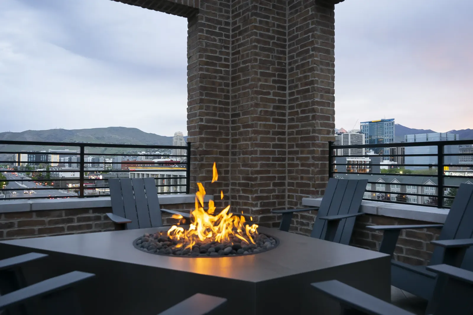 Post House rooftop fire pit and chimney with Adirondack chairs at dusk