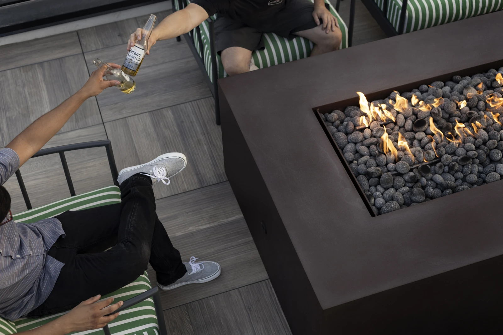 Residents gathered around a rooftop fire pit with the city skyline beyond