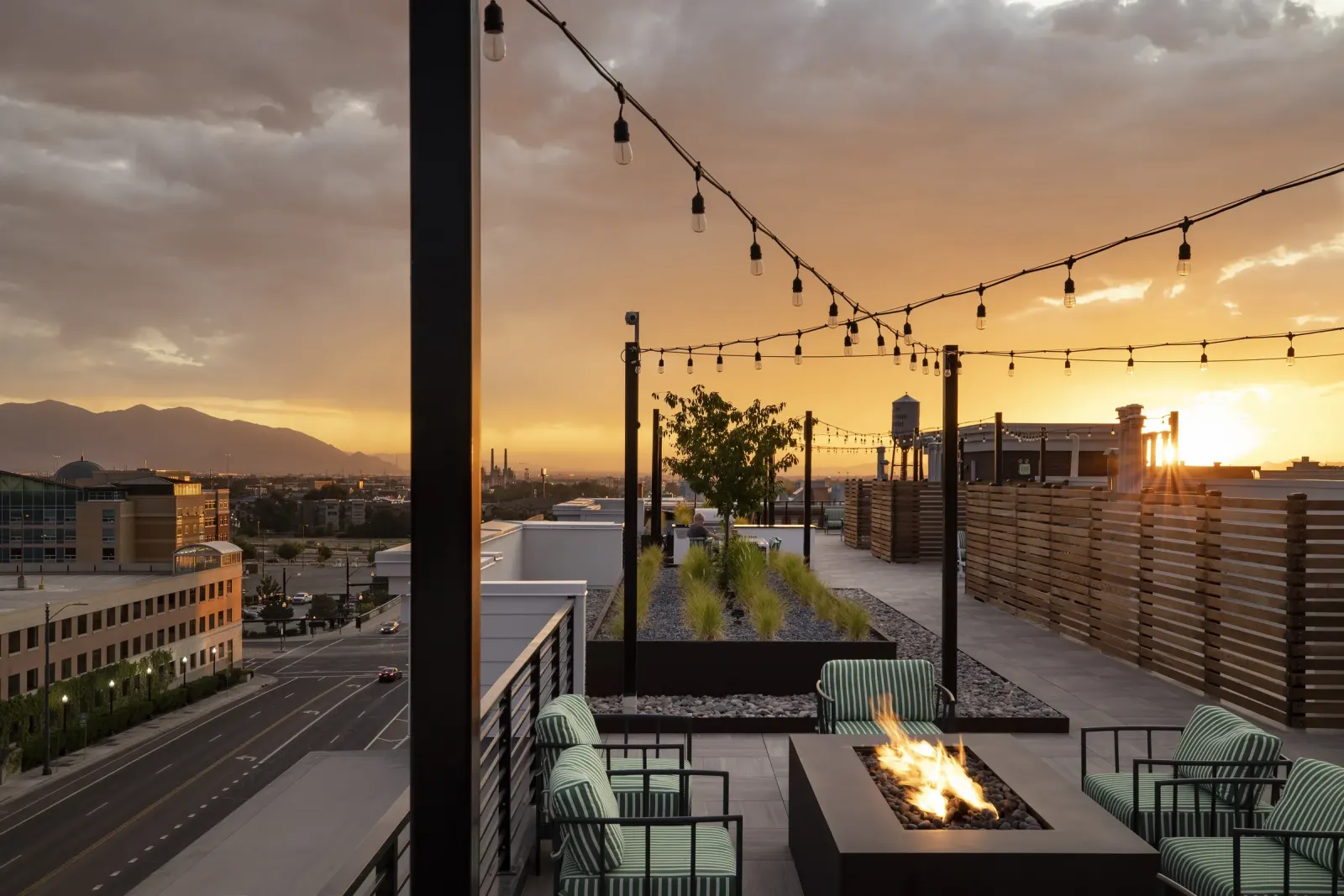 Skyhouse rooftop fire table and planted lounge overlooking the city at sunset